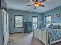 blue painted bedroom with bed and ceiling fan overhead