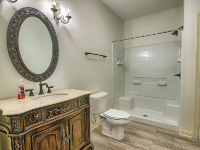 bathroom with large round mirror, white bathtub